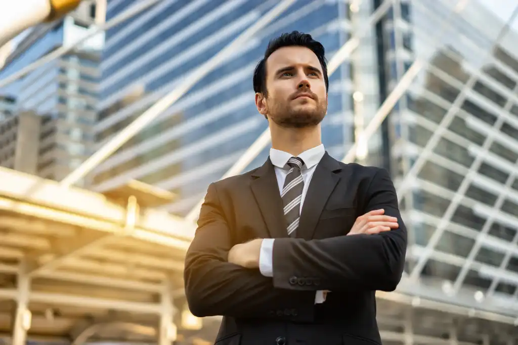 Serious man employer waiting for start interview or startup meeting, male confident CEO expects a partner sign an agreement, Smart handsome successful elegant formal suit standing with crossed arms