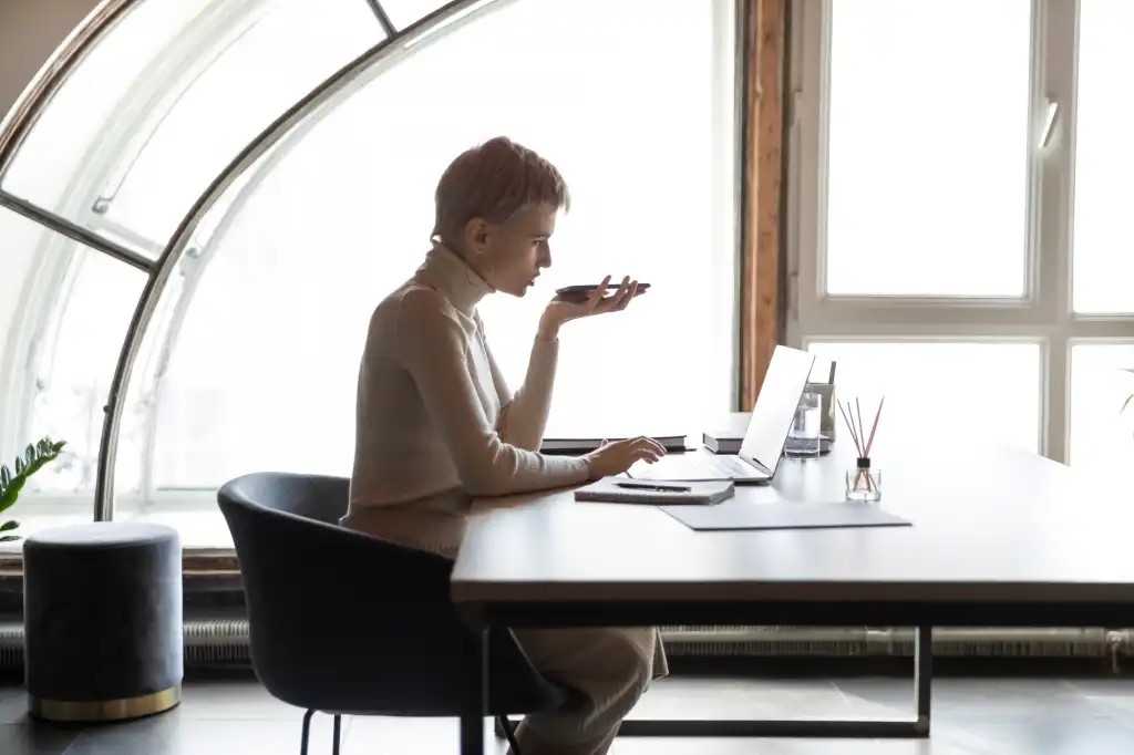 female employee sit at desk in modern office work online on laptop talk