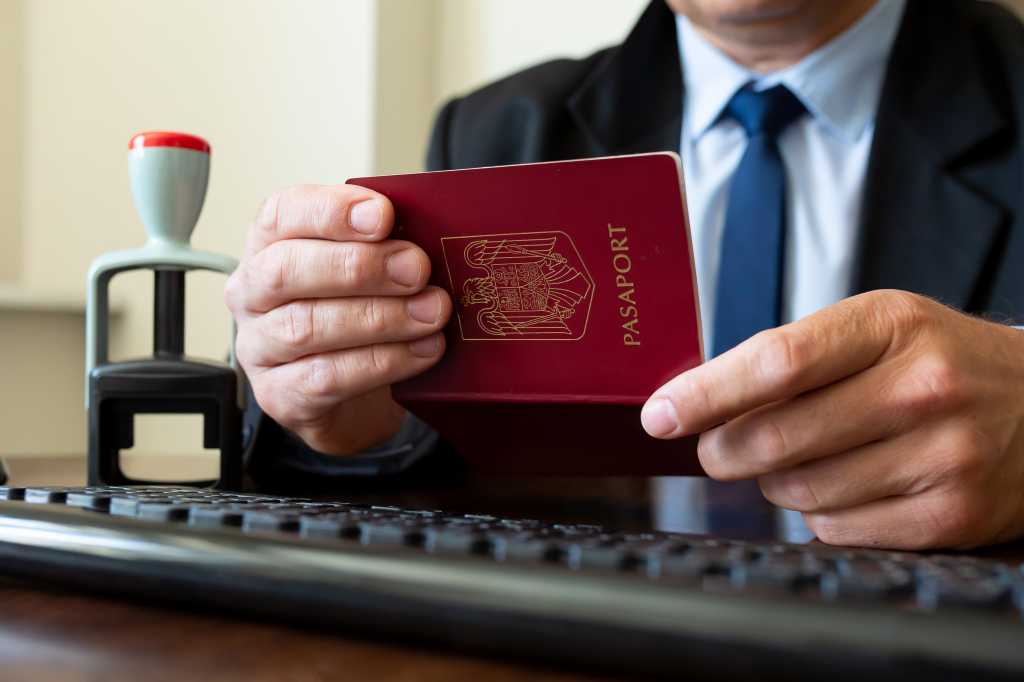 Custom officer checking a travelling passport. Screening of passengers, travellers for Chinese Covid-19 coronavirus symptoms in International airports.