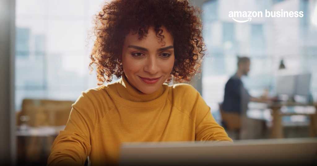 image of woman looking at laptop with a smile on her face